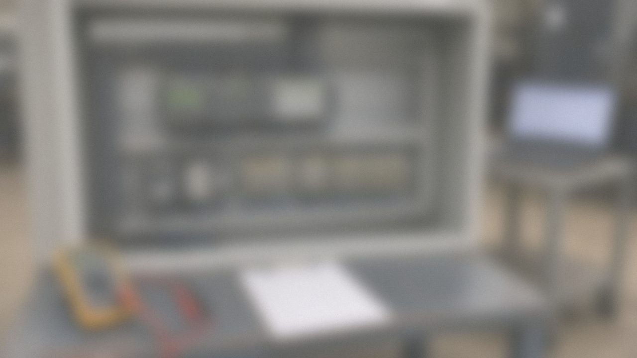 Control panel interior during factory testing with numbered wiring and labeled terminals